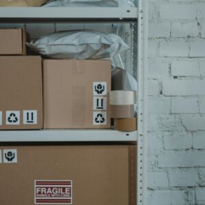 Brown Cardboard Box on Brown Wooden Shelf